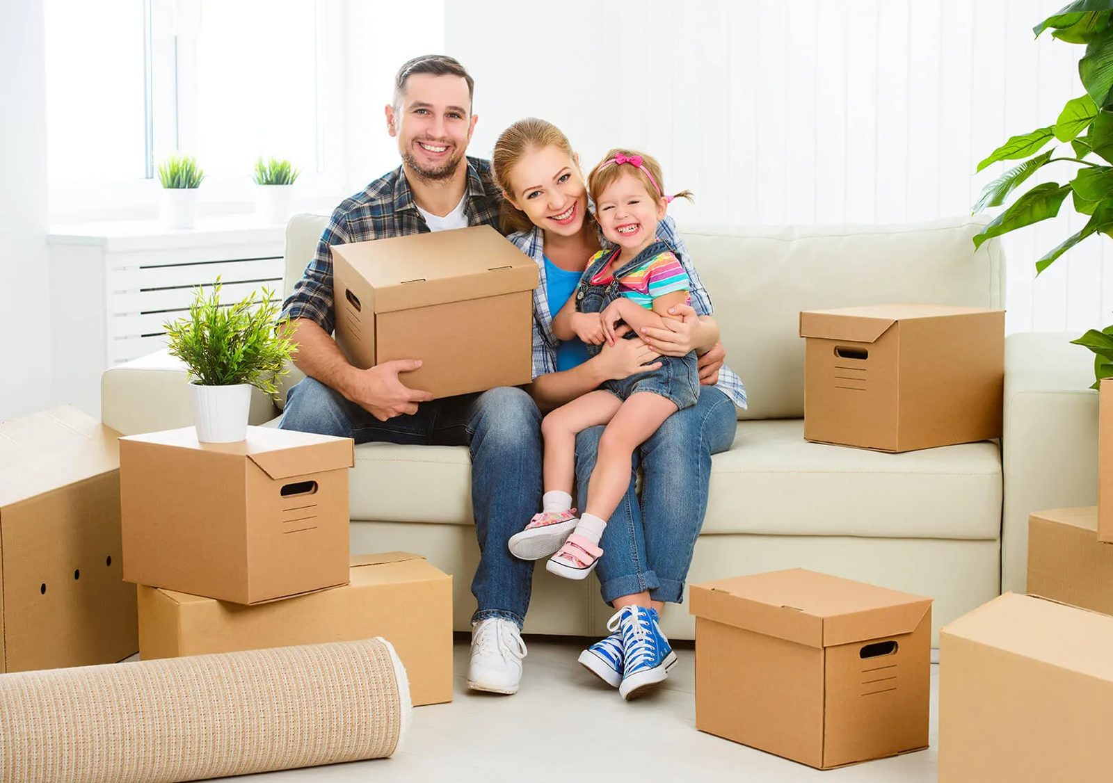 A family sitting among packed moving boxes in their flat