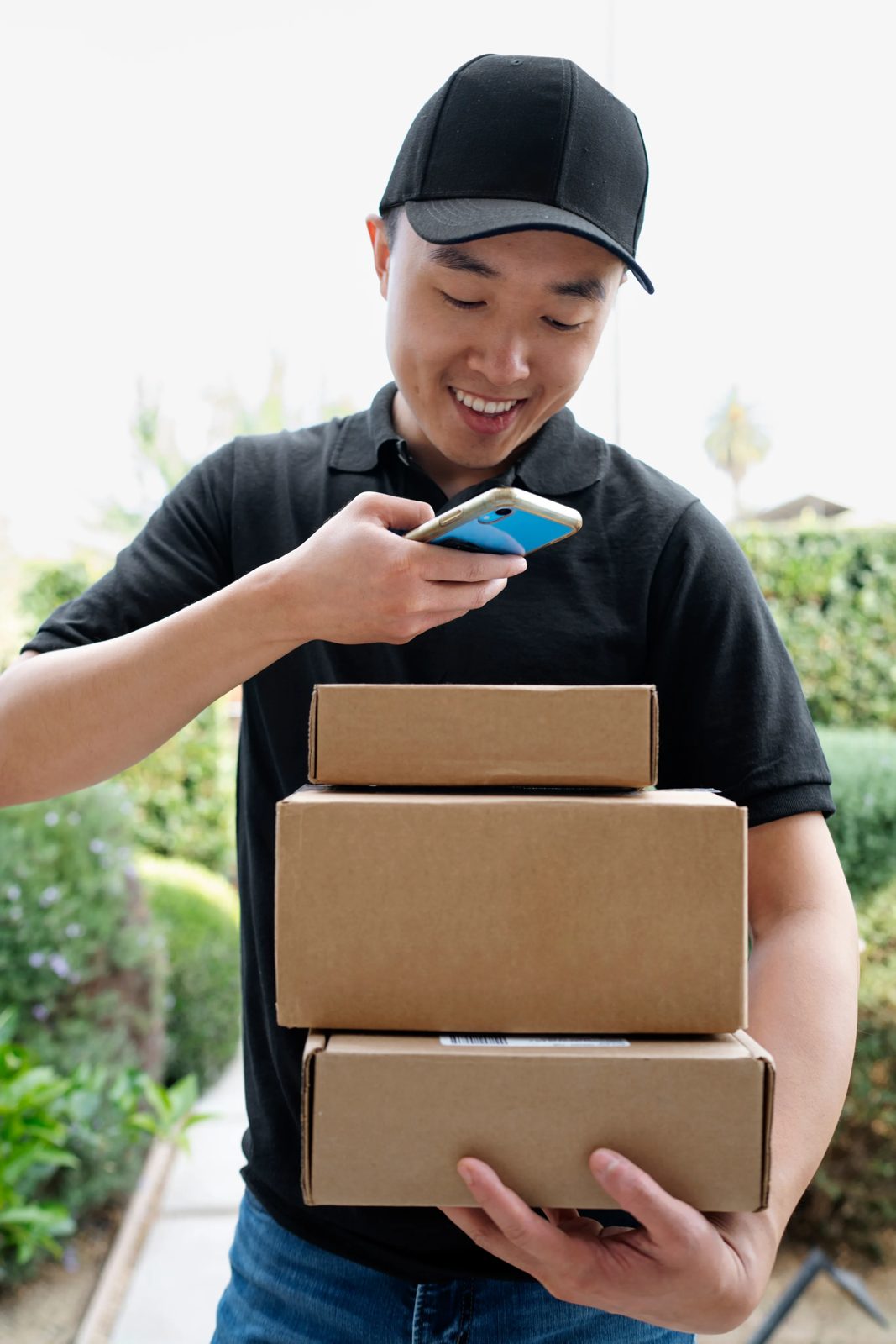 A courier carrying a stack of parcels